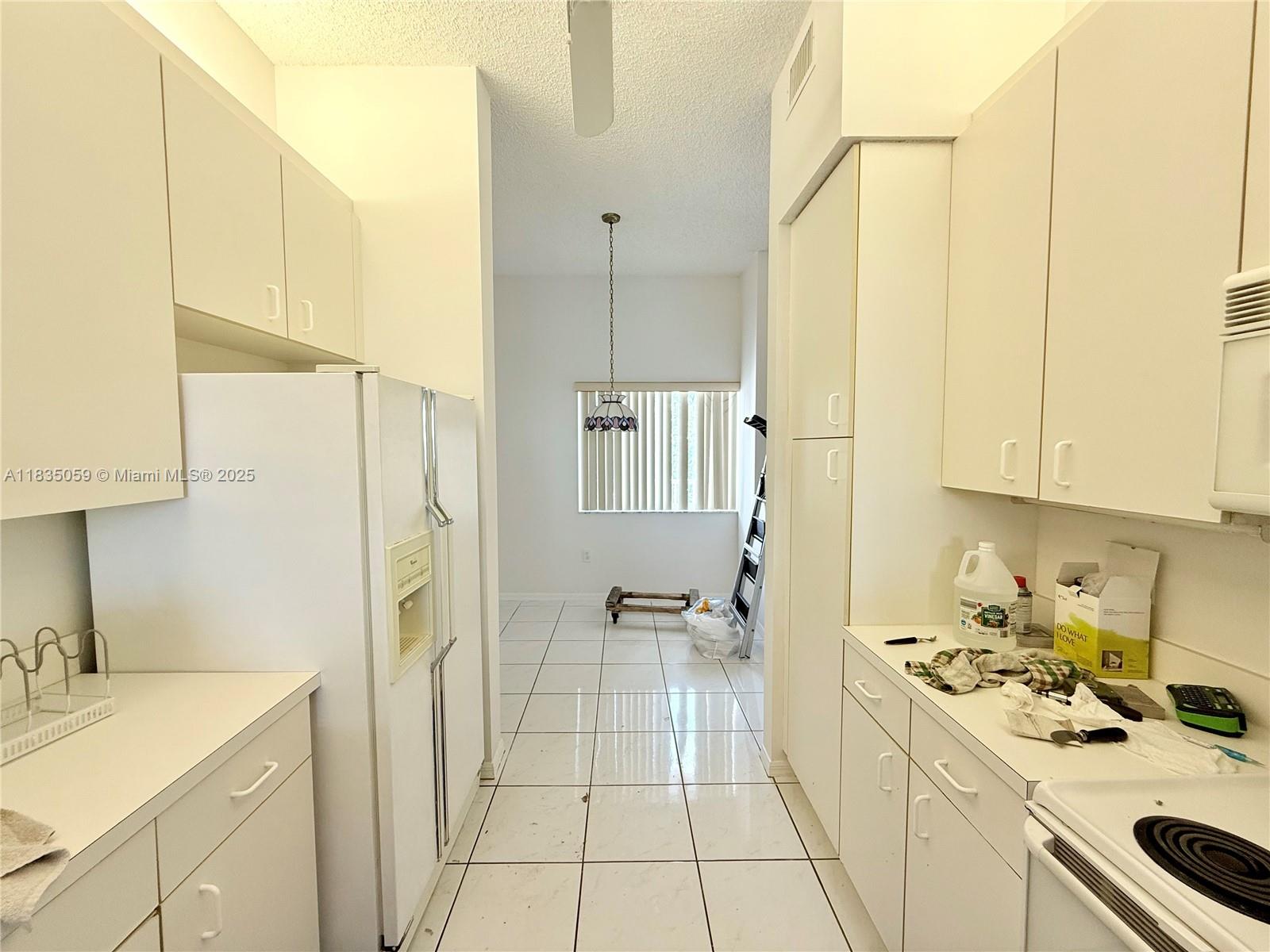 9575 Weldon Circle, Unit C406 Tamarac, FL 33321 - Photo 11 of 13 a kitchen with a sink a stove and a refrigerator