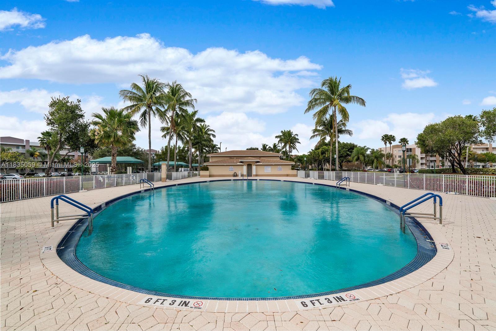 9575 Weldon Circle, Unit C406 Tamarac, FL 33321 - Photo 4 of 13 a view of a swimming pool with a yard
