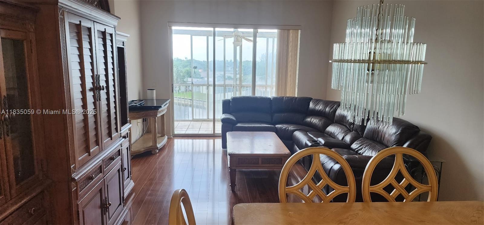9575 Weldon Circle, Unit C406 Tamarac, FL 33321 - Photo 5 of 13 a living room with furniture and a floor to ceiling window