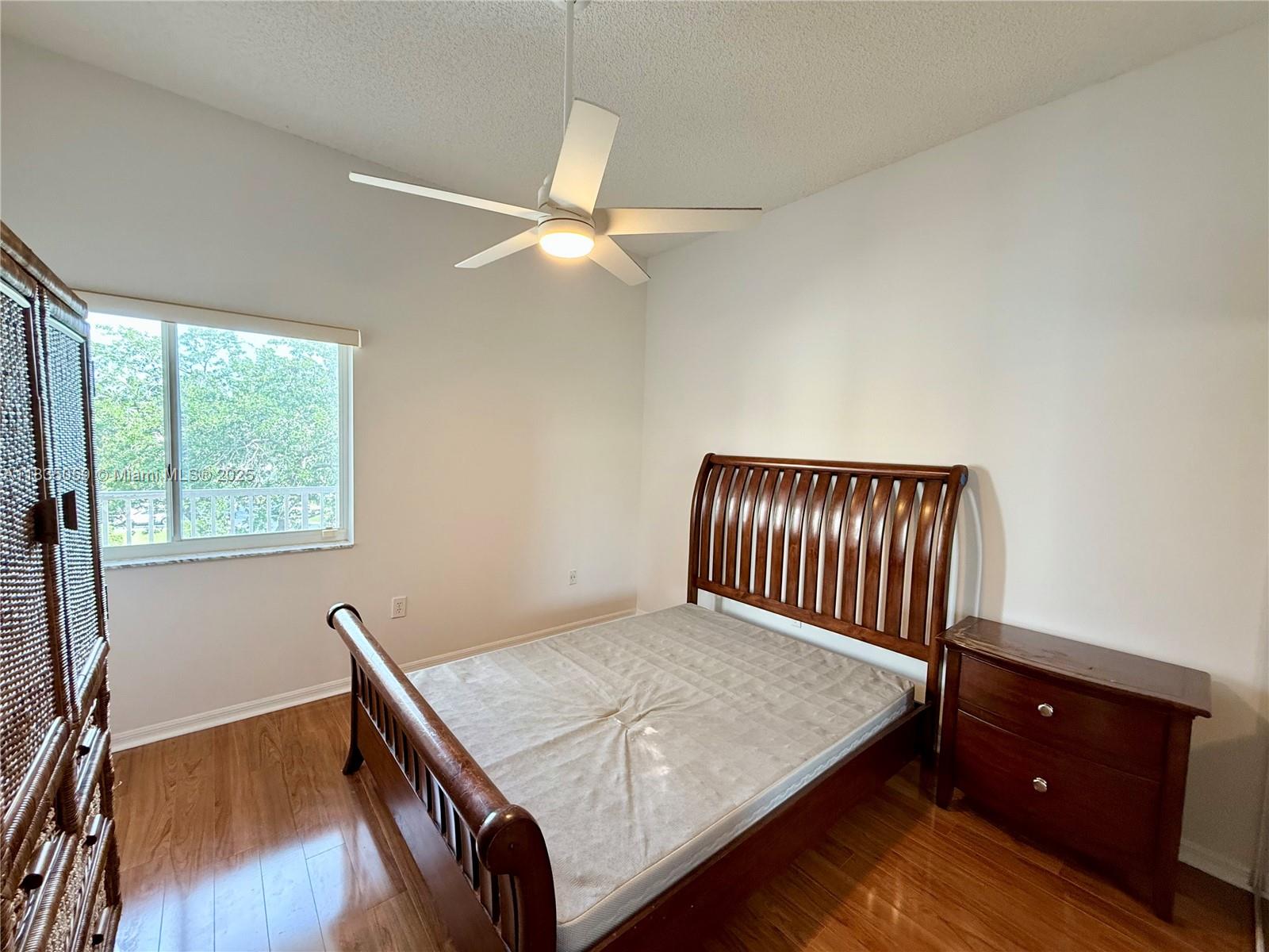 9575 Weldon Circle, Unit C406 Tamarac, FL 33321 - Photo 6 of 13 a bedroom with a bed and a window