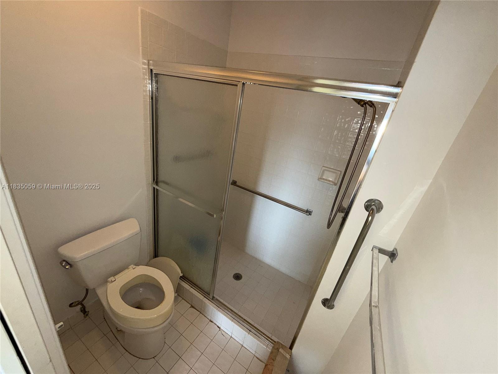 9575 Weldon Circle, Unit C406 Tamarac, FL 33321 - Photo 7 of 13 a bathroom with a toilet and a shower
