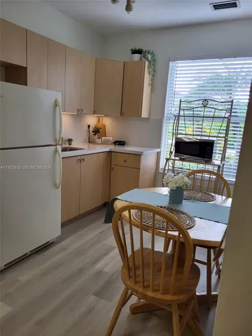 a kitchen with a table chairs a refrigerator and a stove
