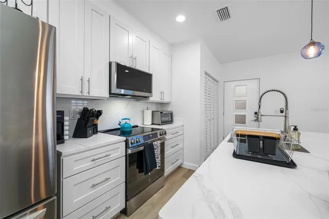 a kitchen with stainless steel appliances granite countertop a stove a refrigerator and a microwave