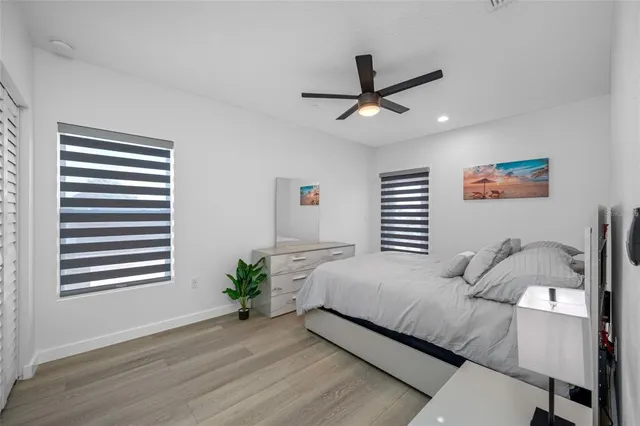 a bedroom with a large bed and a ceiling fan
