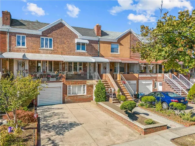 a front view of a house with a yard and potted plants