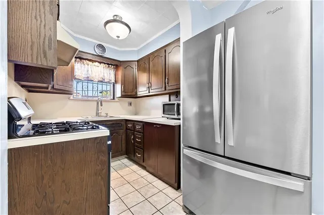 a kitchen with stainless steel appliances granite countertop a refrigerator a stove a sink and a window