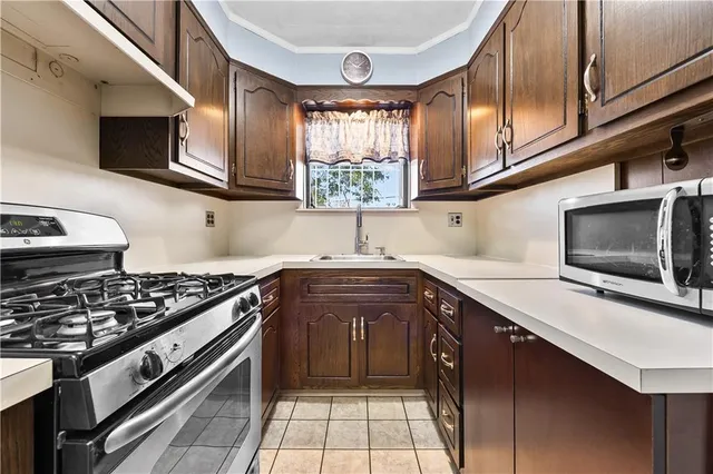 a kitchen with stainless steel appliances granite countertop a stove a sink and a microwave