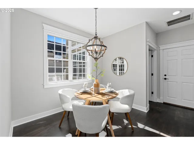 a dining room with furniture a chandelier and wooden floor