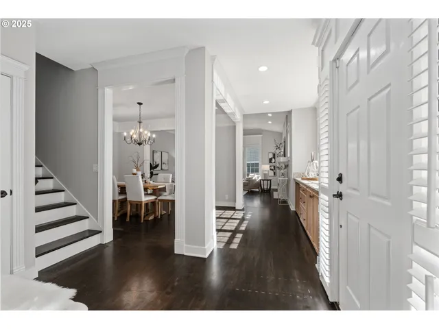 a view of a hallway with wooden floor windows and a livingroom