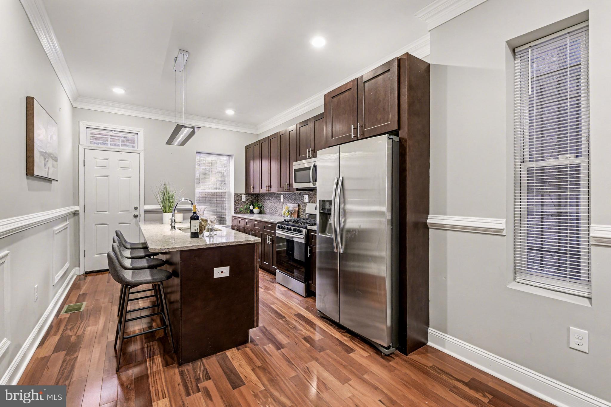 1431 Madison Avenue Baltimore, MD 21217 - Photo 11 of 38 a kitchen with stainless steel appliances granite countertop a refrigerator a sink a stove and a refrigerator
