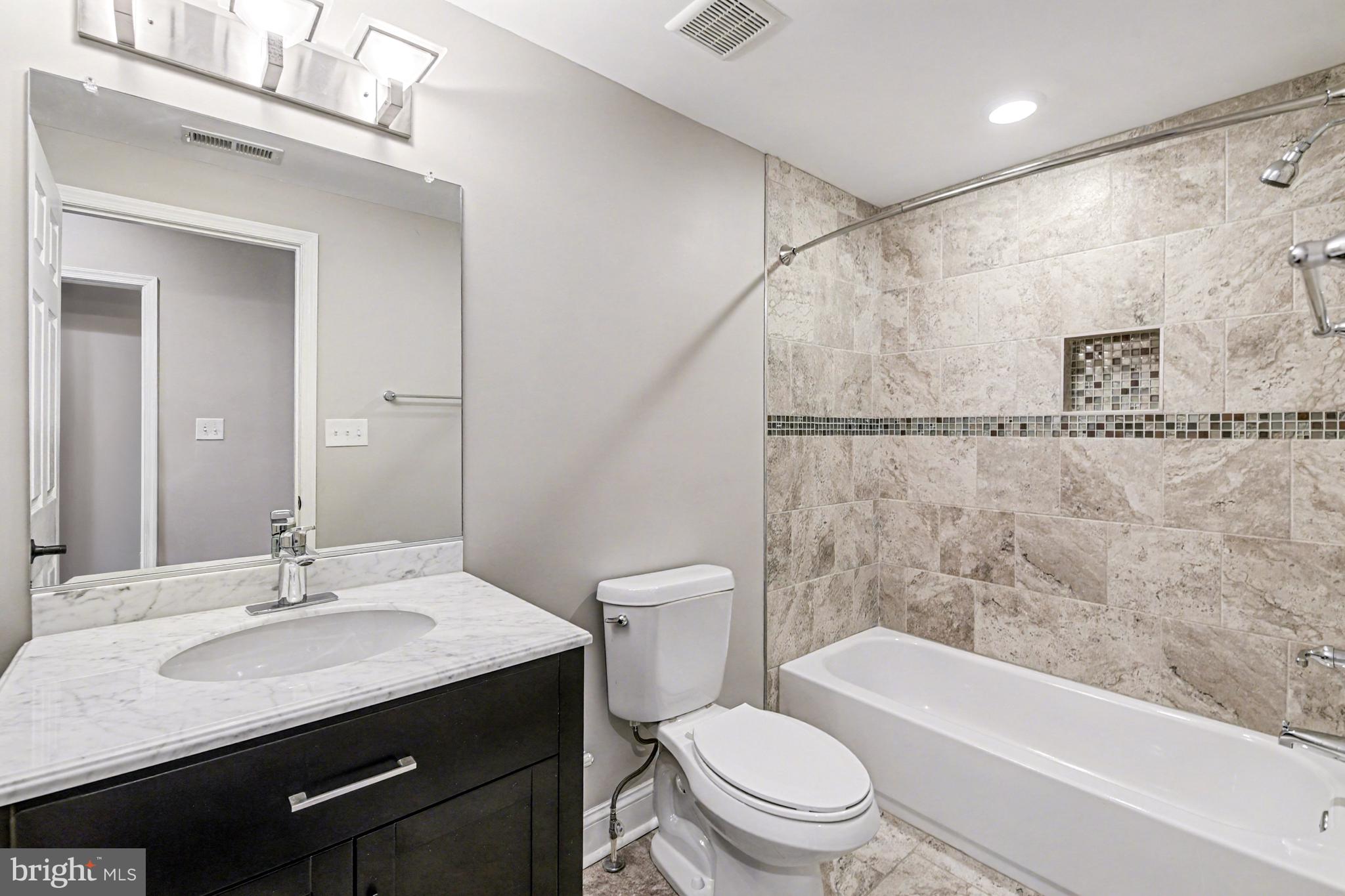 1431 Madison Avenue Baltimore, MD 21217 - Photo 19 of 38 a bathroom with a granite countertop sink toilet and shower