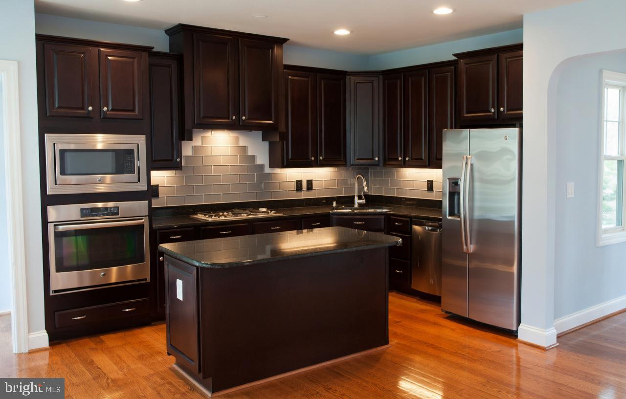 3990 Cephas Child Road Doylestown, PA 18902 - Photo 15 of 53 a kitchen with kitchen island granite countertop stainless steel appliances and wooden cabinets