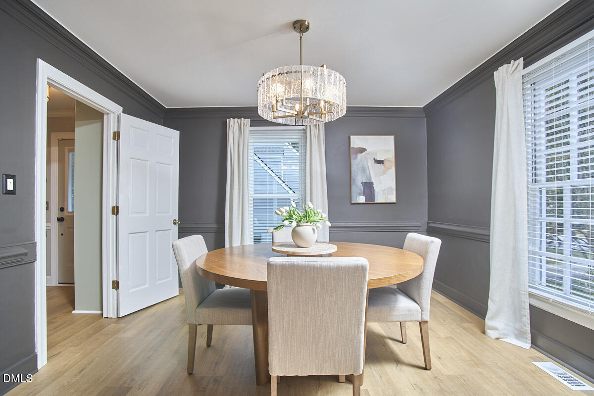 6725 Eastbrook Drive Raleigh, NC 27615 - Photo 23 of 48 a dining room with furniture a chandelier and wooden floor