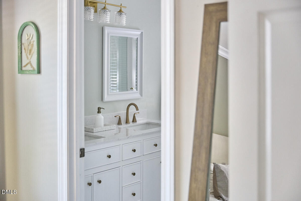 6725 Eastbrook Drive Raleigh, NC 27615 - Photo 30 of 48 a bathroom with a granite countertop sink vanity and mirror