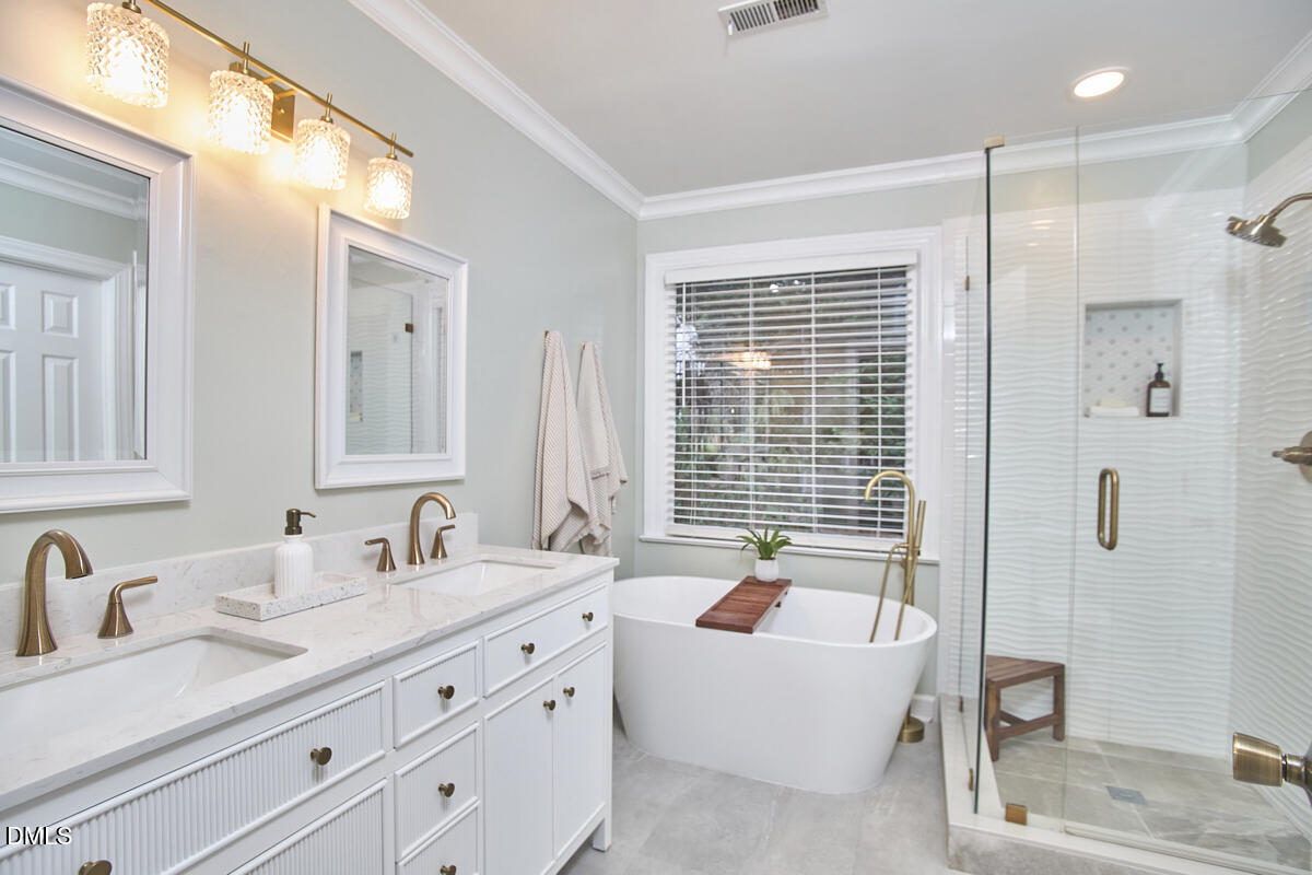 6725 Eastbrook Drive Raleigh, NC 27615 - Photo 31 of 48 a bathroom with double vanity sinks a shower and a mirror