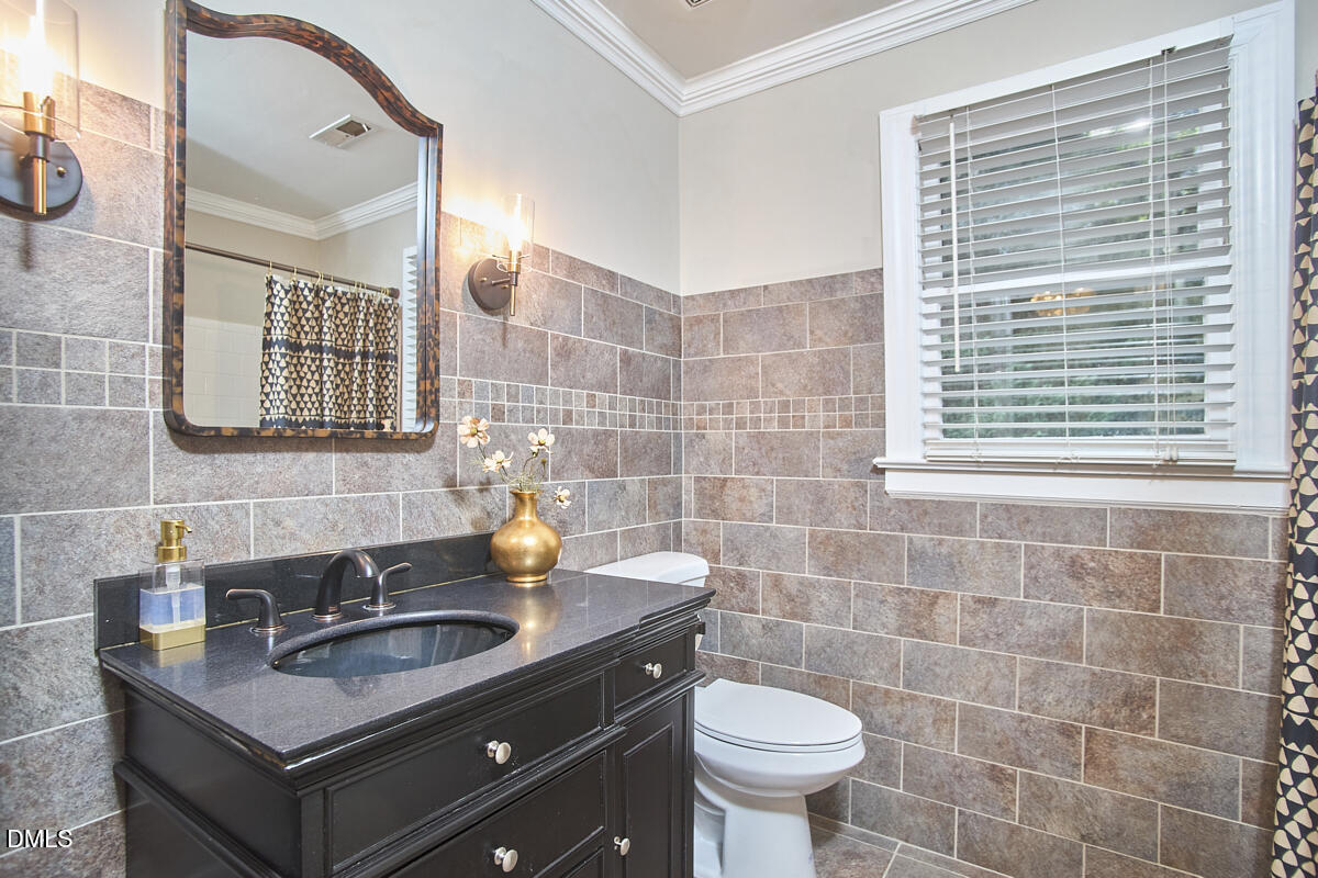 6725 Eastbrook Drive Raleigh, NC 27615 - Photo 36 of 48 a bathroom with a sink a toilet a mirror and shower