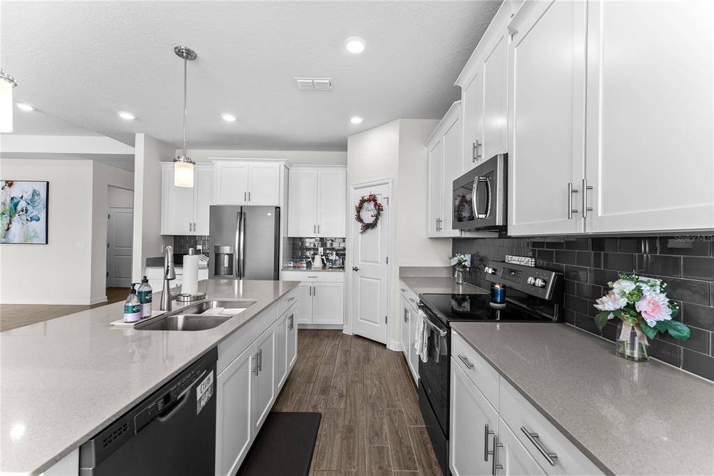 2926 Wordsmith Road Kissimmee, FL 34746 - Photo 22 of 42 a kitchen with kitchen island granite countertop a sink counter top space appliances and cabinets
