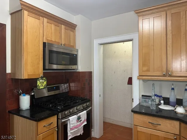 a kitchen with granite countertop cabinets stainless steel appliances a sink and a window