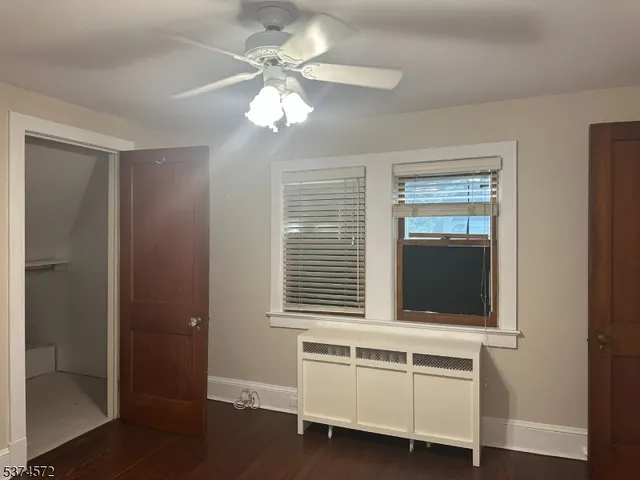 a view of a livingroom with a chandelier fan and windows