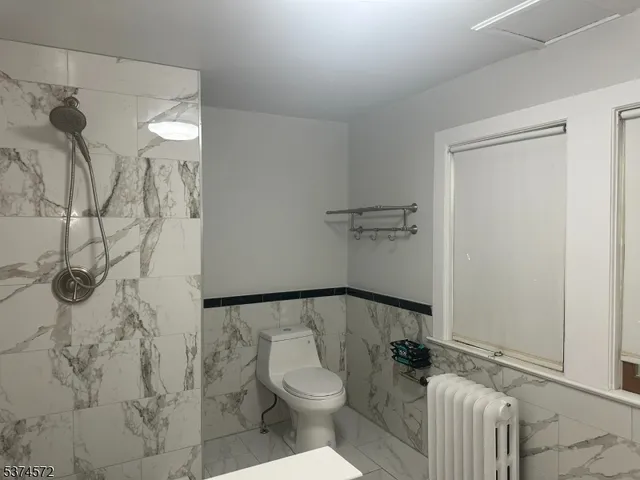 a bathroom with a granite countertop shower and a toilet