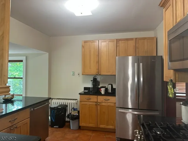 a kitchen with a refrigerator and a stove top oven