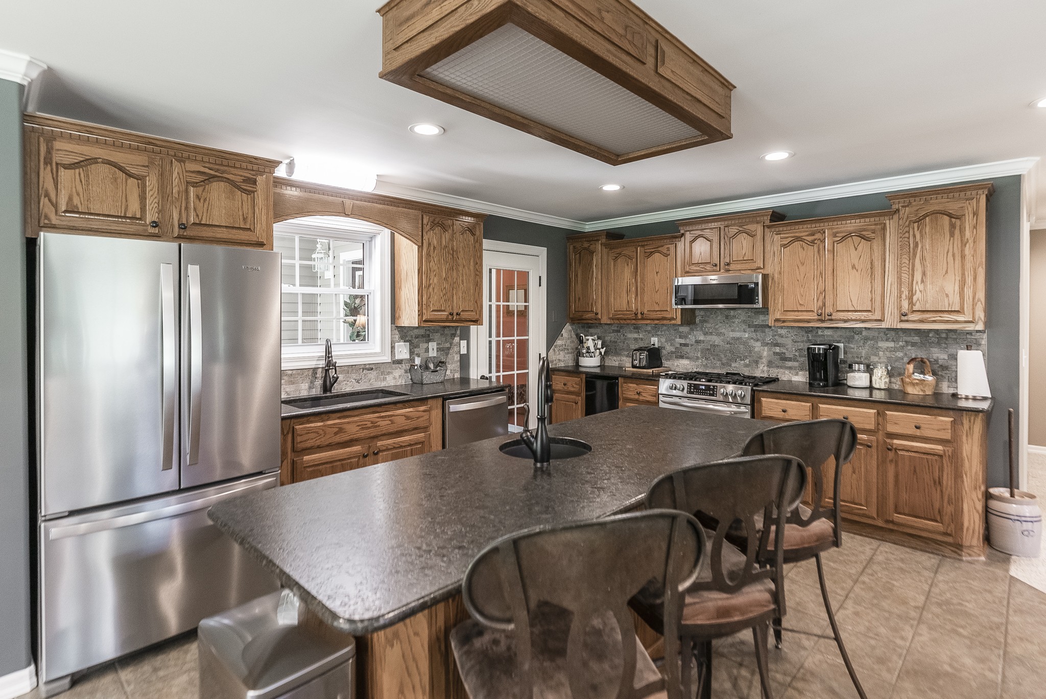 443 Mt Vernon Road Bethpage, TN 37022 - Photo 10 of 40 a kitchen with stainless steel appliances granite countertop a refrigerator a stove a sink a dining table and chairs with wooden floor