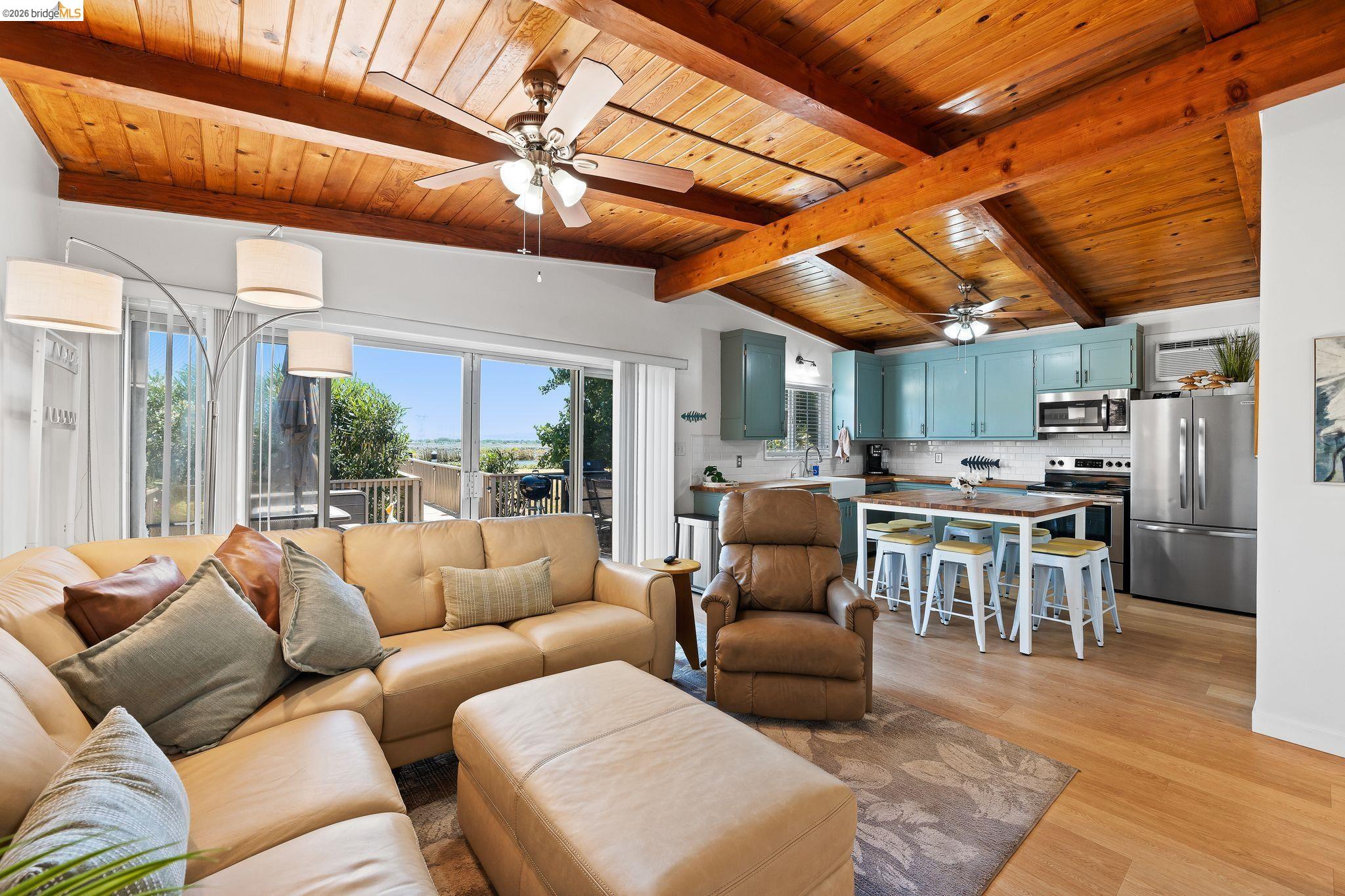 1704 Taylor Road Bethel Island, CA 94511 - Photo 24 of 73 Open-concept living space featuring wood-finish flooring, exposed wood beam ceiling, and sliding glass doors to the exterior