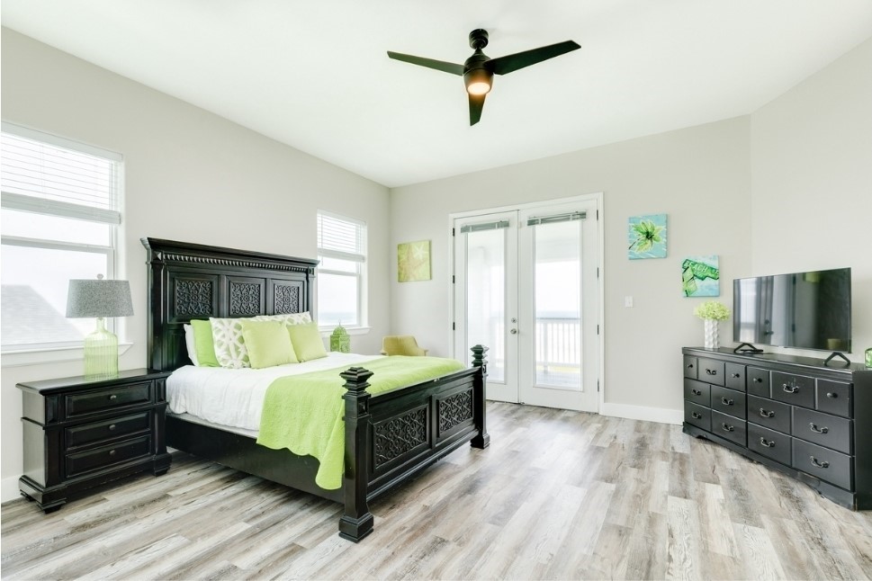 23327 Termini-San Luis Pass Road Galveston, TX 77554 - Photo 21 of 39 a bedroom with a bed a dresser and a flat screen tv