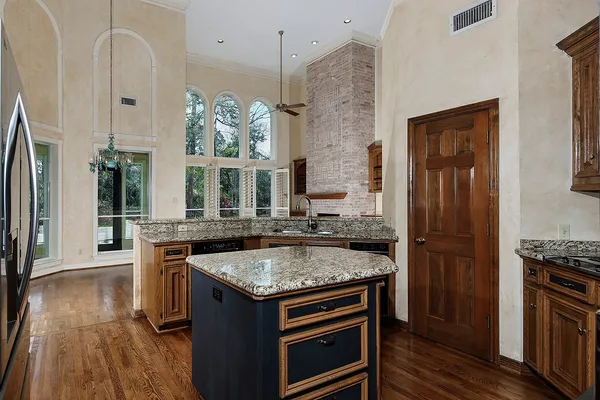 an empty room with wooden floor fireplace and windows
