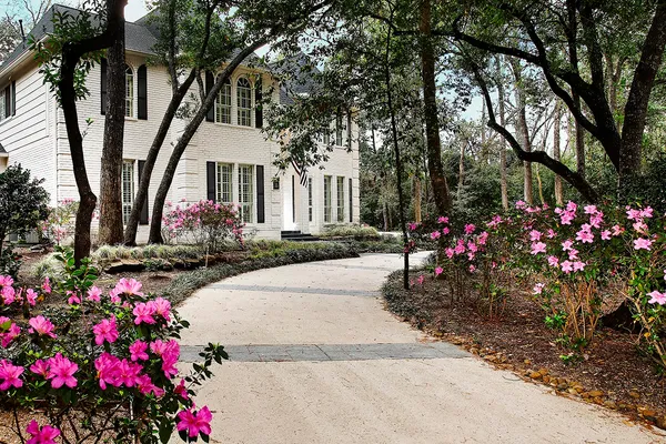 a front view of a house with yard and fountain