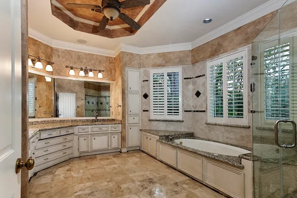 a bathroom with a granite countertop bathtub and shower