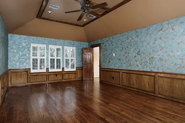 a view of an empty room with wooden floor and closet