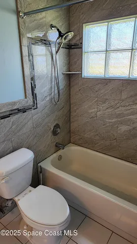 a bathroom with a toilet and a tub