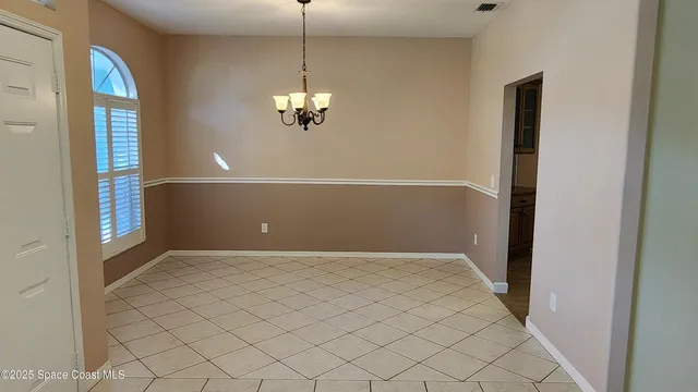 an empty room with chandelier fan