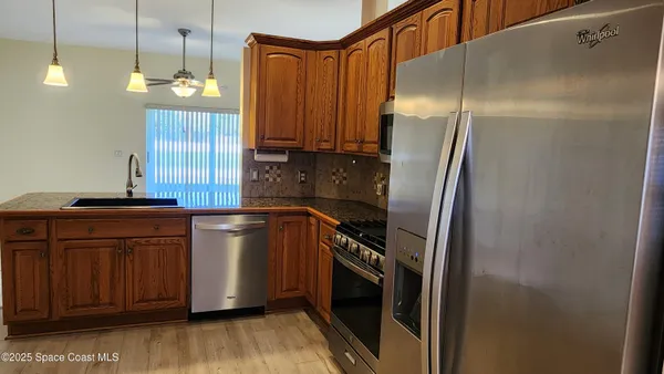 a kitchen with stainless steel appliances granite countertop a refrigerator and a sink