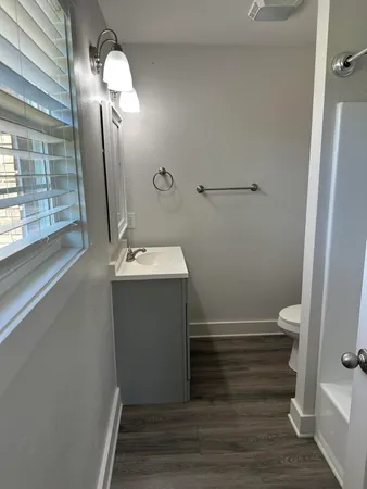 a bathroom with a sink a toilet and shower