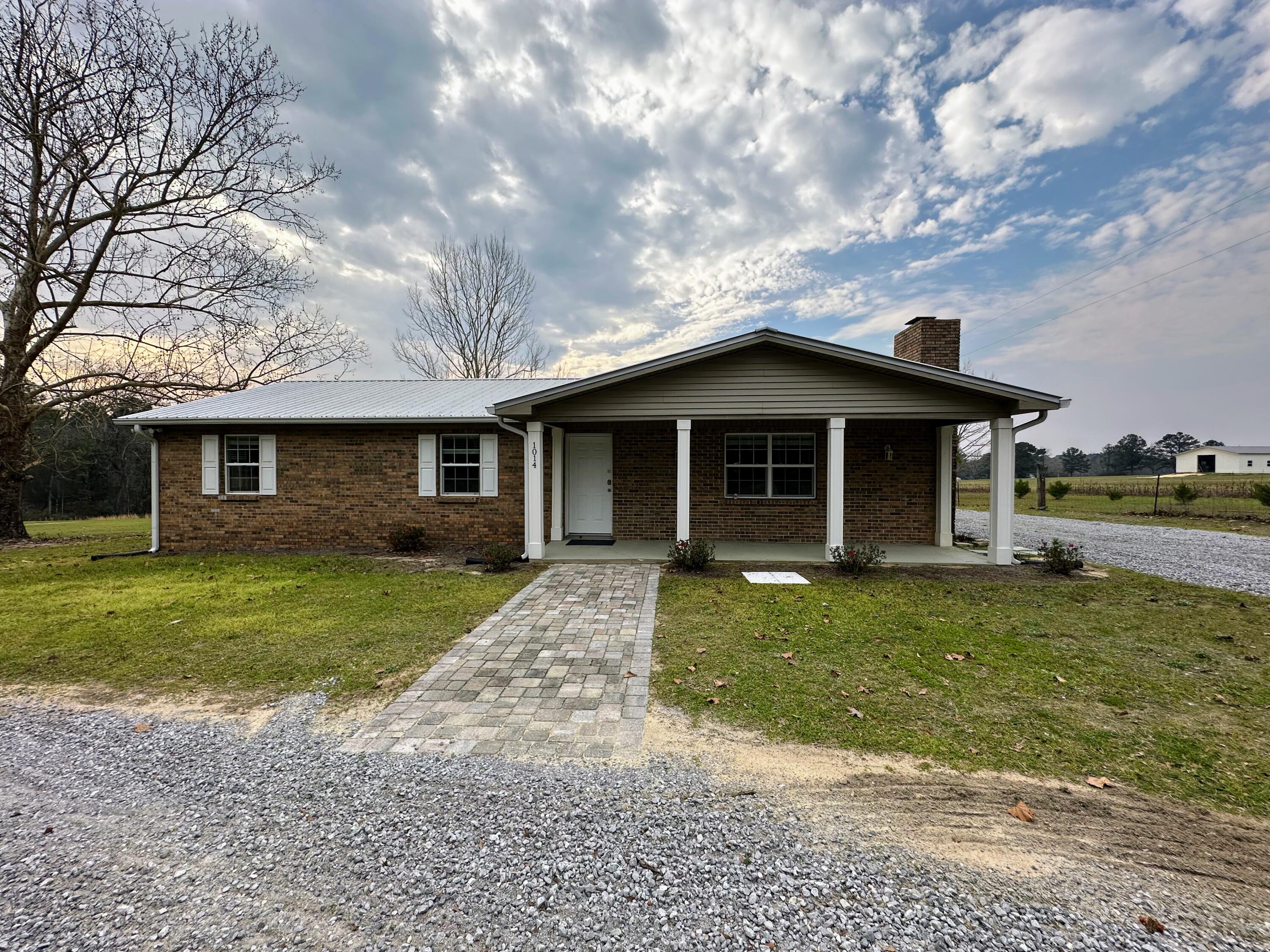 1014 East Indian Creek Ranch Road DeFuniak Springs, FL 32435 - Photo 14 of 17 a front view of a house with a garden