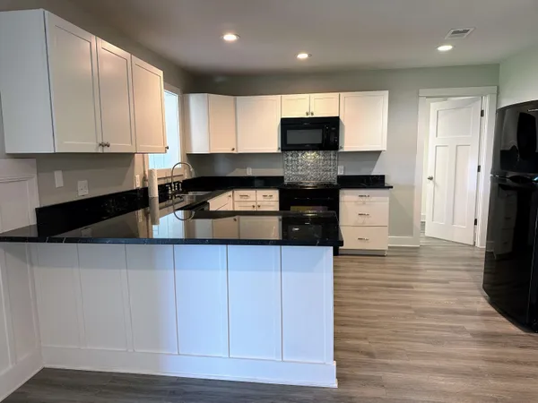 a kitchen with stainless steel appliances granite countertop a refrigerator and a stove top oven