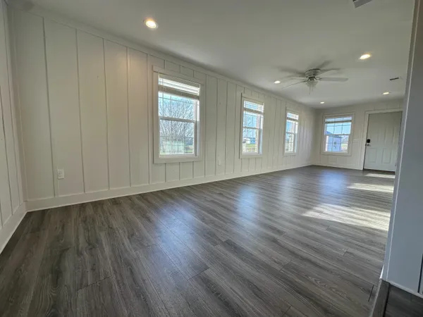 an empty room with wooden floor and windows