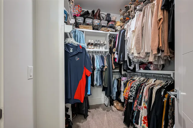 a view of walk in closet with clothes