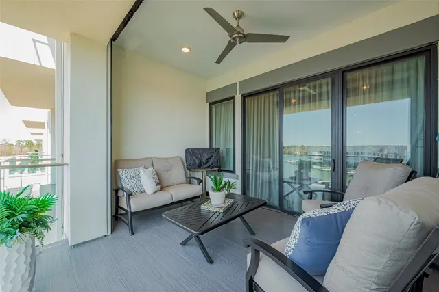 a living room with furniture and a floor to ceiling window