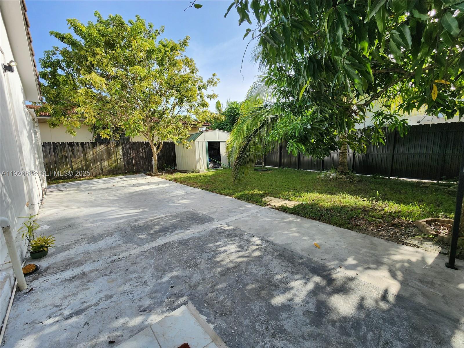 2438 Southwest 114th Avenue Miami, FL 33165 - Photo 12 of 15 a view of a yard with plants and large trees