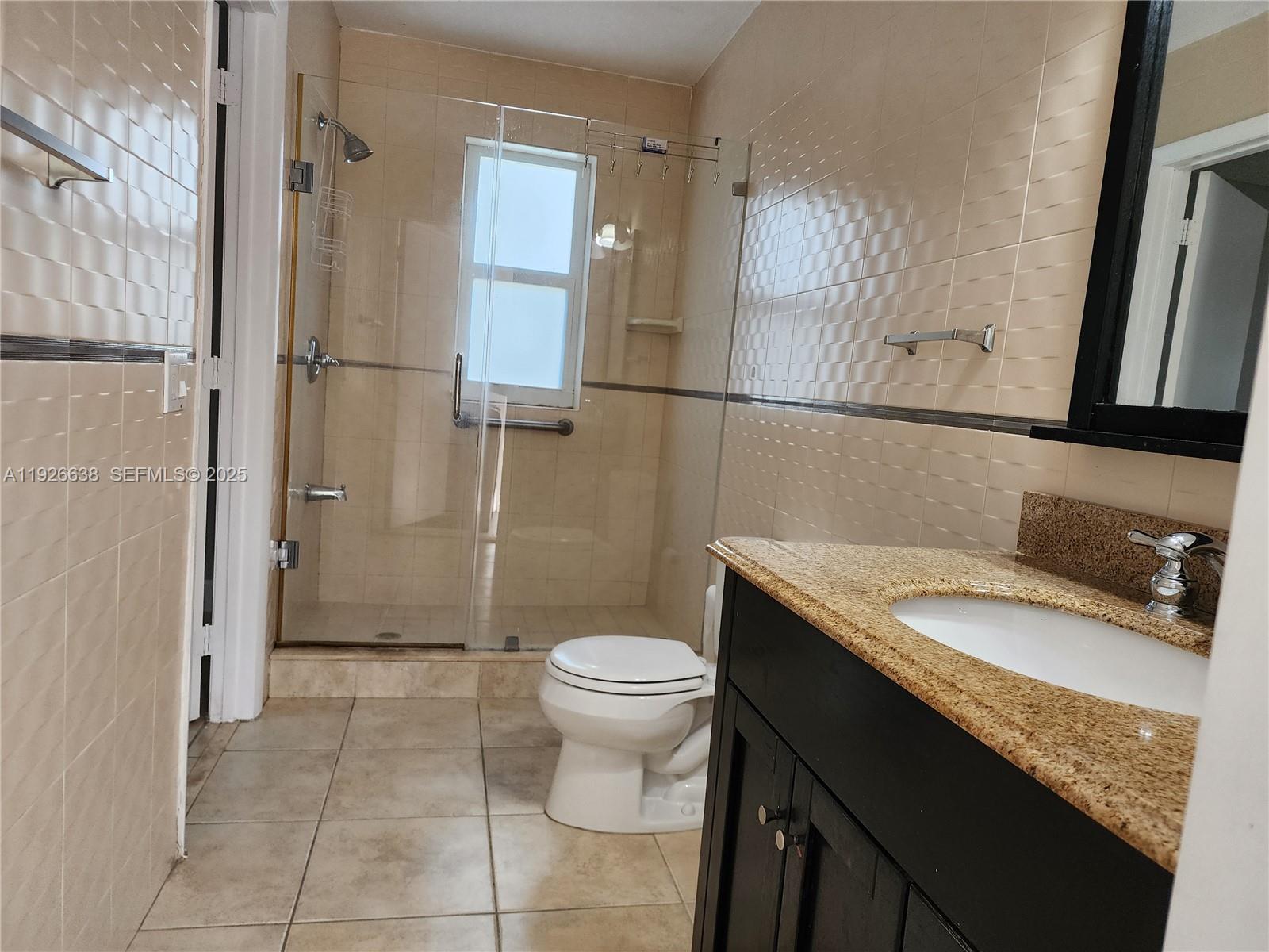 2438 Southwest 114th Avenue Miami, FL 33165 - Photo 10 of 15 a bathroom with a granite countertop sink a toilet and shower