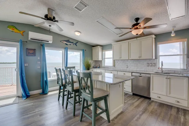 a kitchen with stainless steel appliances granite countertop wooden floor dining table and chairs