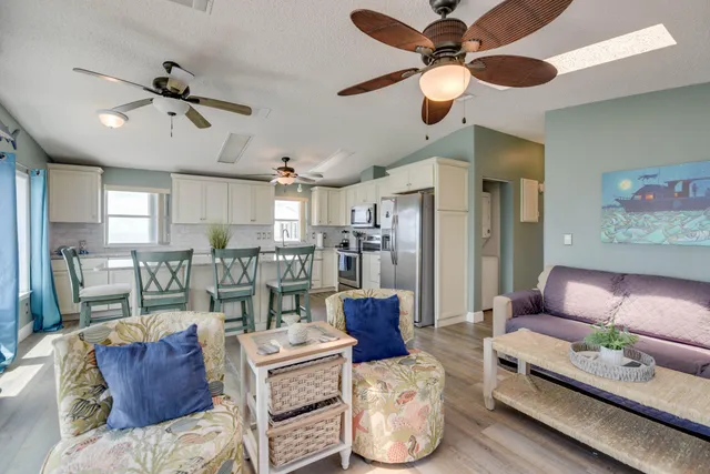 a living room with furniture kitchen view and a chandelier