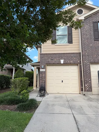 front view of a house with a yard and garage