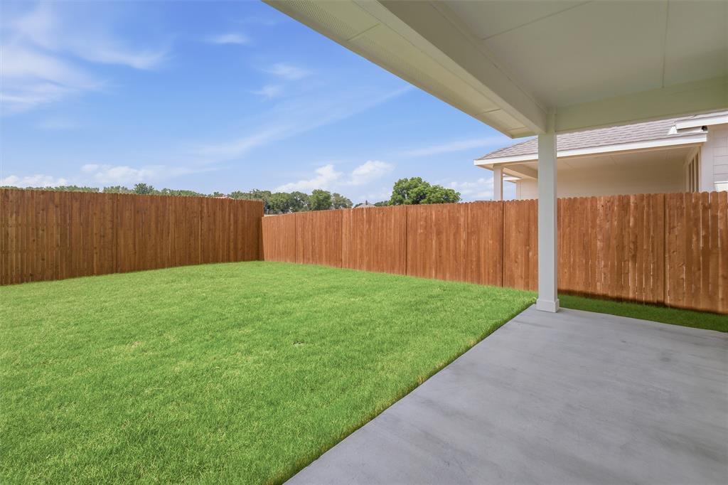 1232 Colca Drive Springtown, TX 76082 - Photo 18 of 23 Expansive backyard featuring a manicured lawn and privacy fencing, complemented by a covered concrete patio