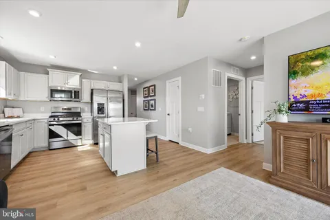 a view of kitchen with microwave stove refrigerator and cabinets