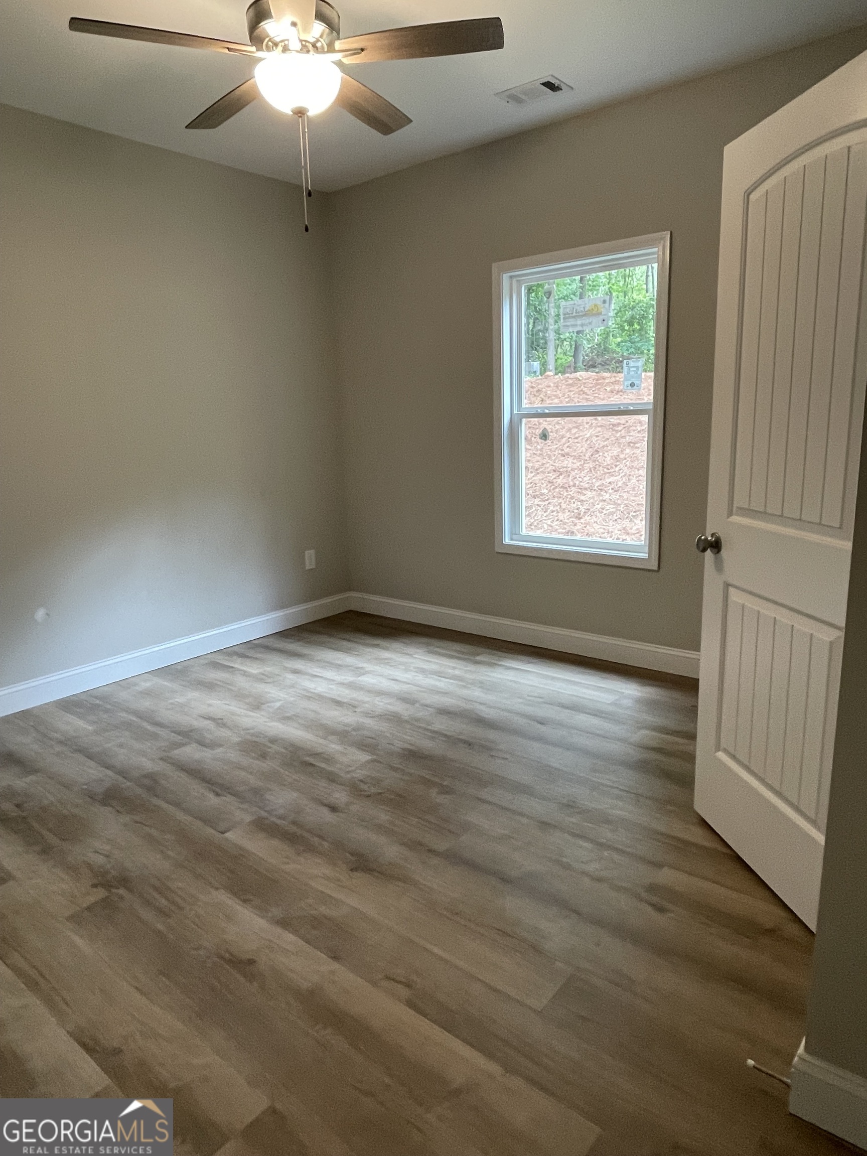 115 Drues Road Bowdon, GA 30108 - Photo 13 of 13 an empty room with wooden floor and windows
