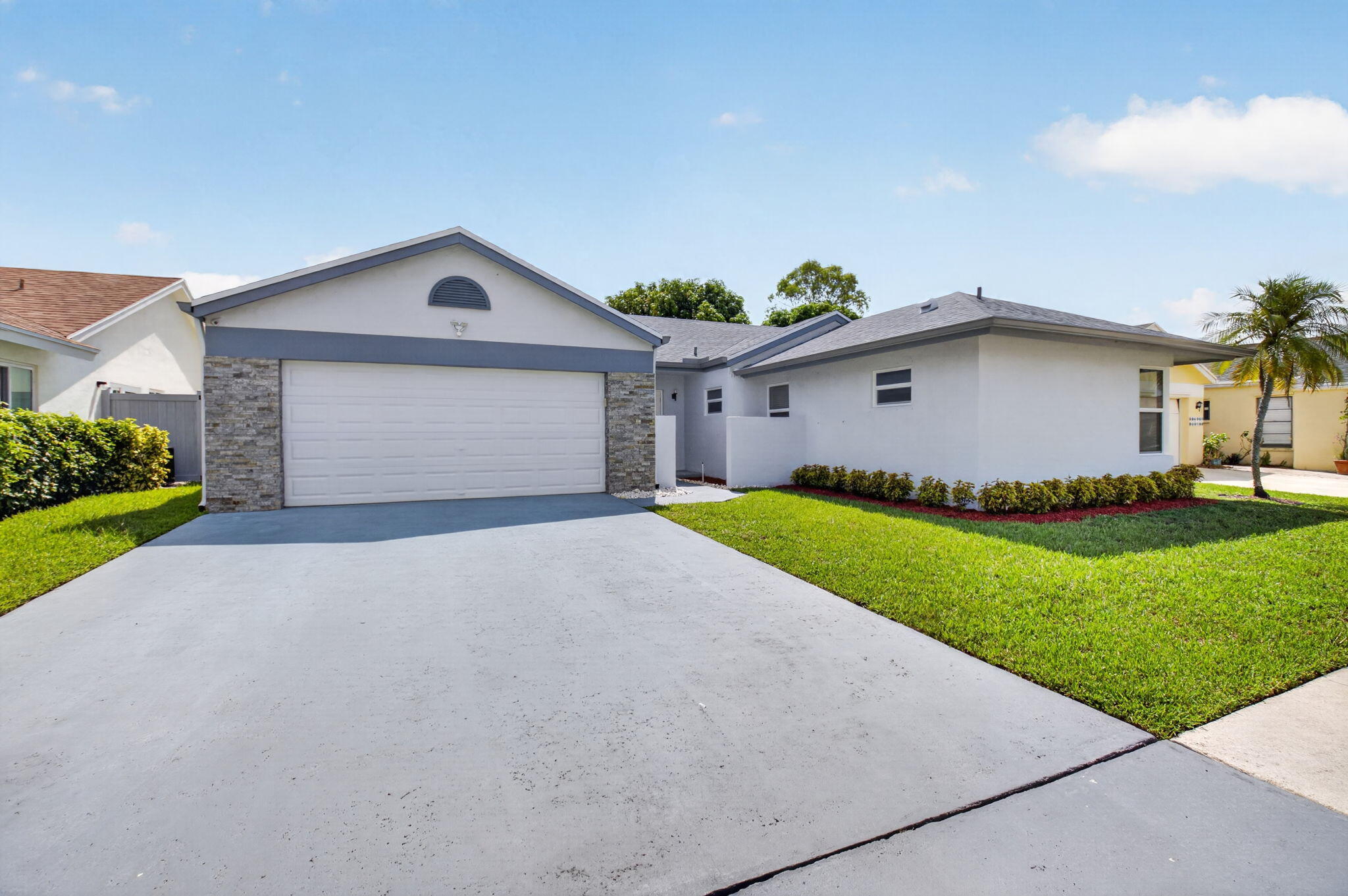 21070 Woodspring Avenue Boca Raton, FL 33428 - Photo 2 of 30 a front view of a house with a yard and garage